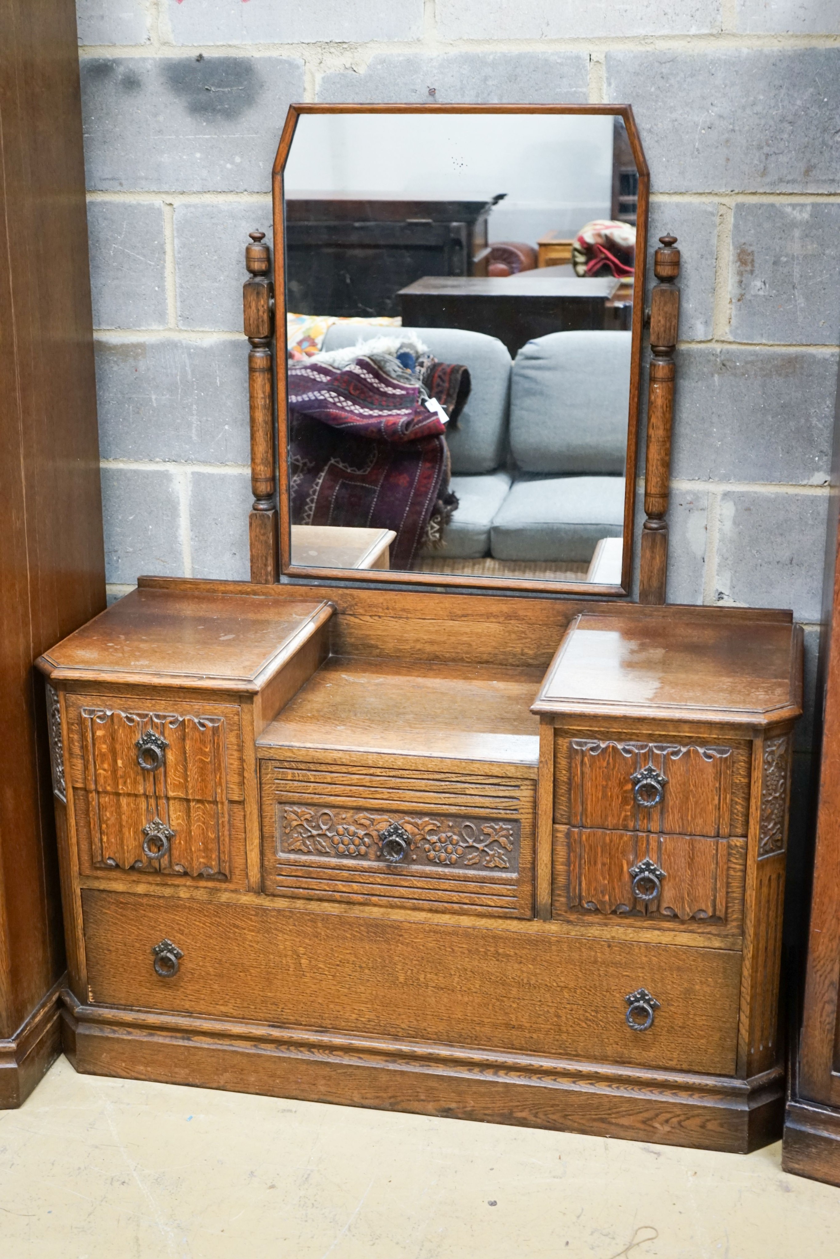 An early 20th century Jacobean revival linenfold moulded oak three piece bedroom suite, larger wardrobe length 128cm, depth 58cm, height 183cm